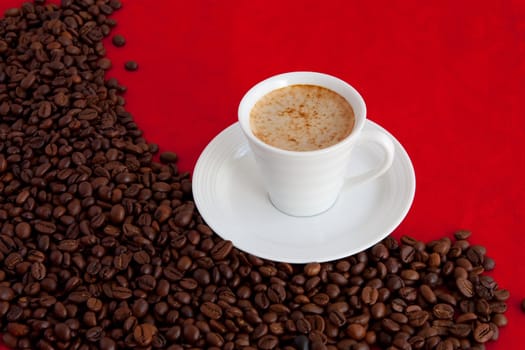 cup with coffee and grain expressed on red background
