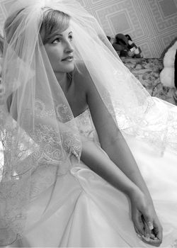 Three quarter black and white images of pretty young adult blond bride in wedding dress with veil.