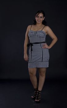 Young latino women in black in white dress with checkers motive
