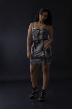Young latino women in black in white dress with checkers motive