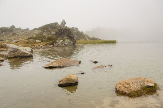 Foggy day mountain lake in Pyrenees mountain - Andorra.