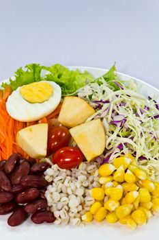 Fruit salad with boiled egg on a white plate