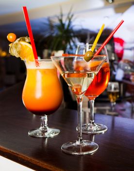 Tequila sunrise, Margarita and Martini standing on the bar counter