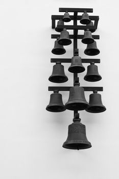 Row of black bells in a prison courtyard.