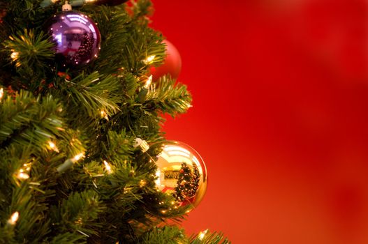 gold reflective ornament ball on a Christmas tree with red background