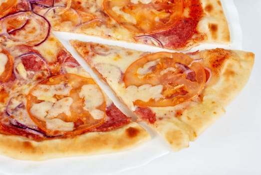pizza closeup with salami, tomato, onion and mozzarella cheese