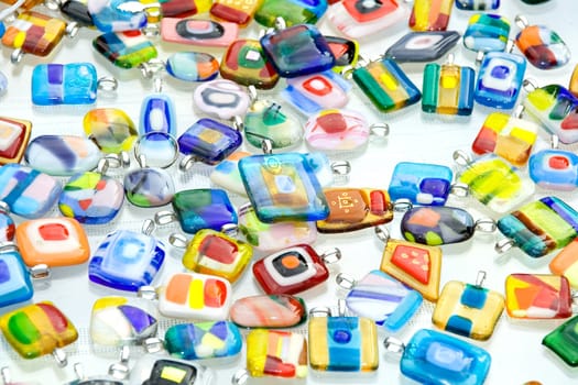 Pendants made of colored glass arranged on a light surface