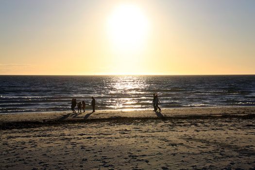 Family and Couple walking along beach before Sunset. Semaphore Beach, Adelaide, Australia