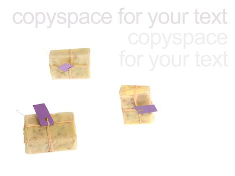 Three natural soaps wrapped with handmade paper isolated over white background. 