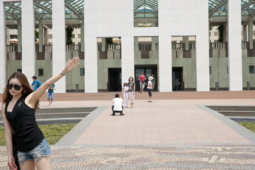 Tourist shows off for the camrea in front of Australia's Parliament House, Canberra in 2011.