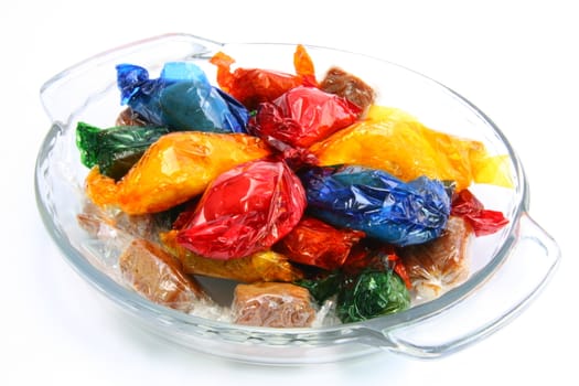 butterscotch  pastries in colored wrapping  served in a dish
