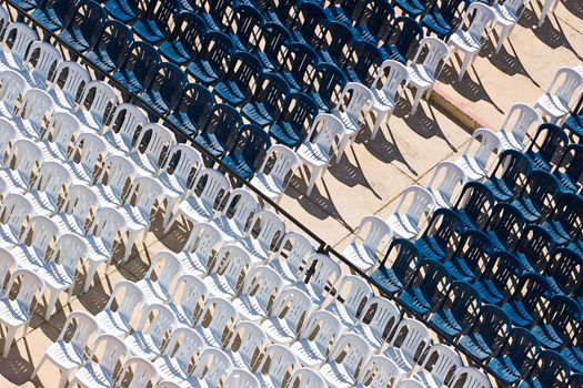 Rows of white and blue plastic chairs with no occupants