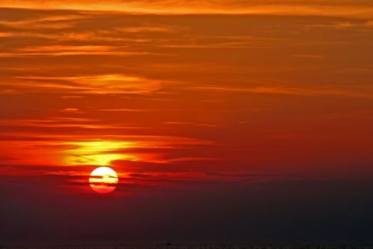 Sun setting over the sea with clouds