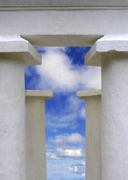 White temple pillars against summery blue sky