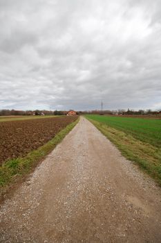 Part through fields under stormy sky