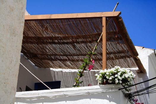 a white and flowered balcony of a summer house covered and fresh.
