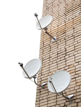 Three satellite antennas on the home front on the background wall of bricks 