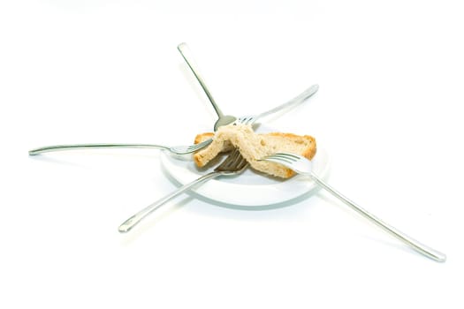 Some forks, white plateau and bread slice on a white background.  The concept of limitation of resources.
The concept  sharing between consumers.

