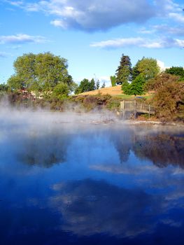 Geothermal Activity of Kuirau Park, with wooden lookout and cloud reflections through the steam. Rotorua, New Zealand