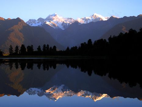 Mount Cook and Mount Tasman reflected in Lake Matheson at Sunset. New Zealand