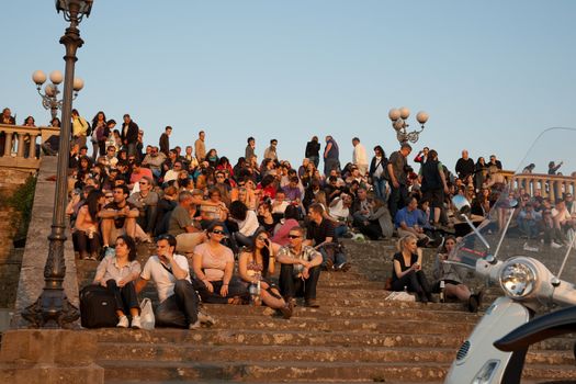 Tourists gather on steps at Michelangelo caerpack, Florence, Italy as they do nightly to witness the sunset of this beautiful city.