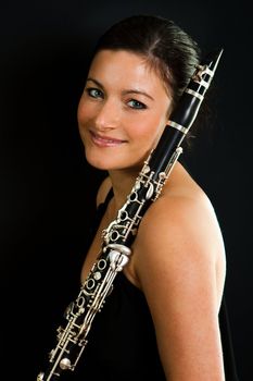 Portrait of beautiful clarinetist women on black background