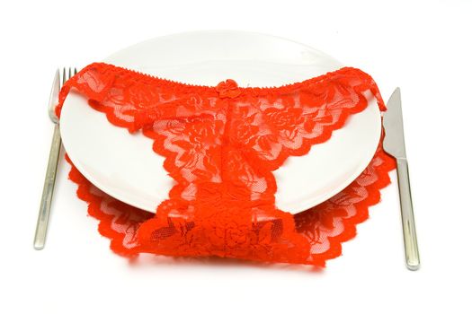 Red Women's elegant and sexy panties, lying on a white dish