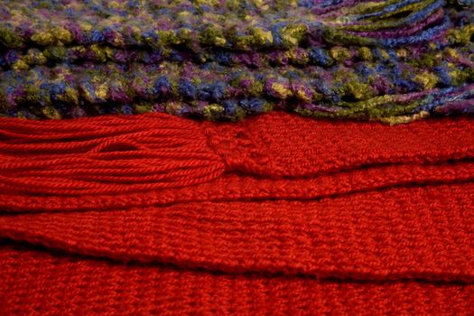 Close-up of two colorful wool scarfs