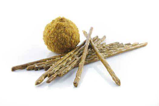 Small tasty scotch egg with salty pretzel  sticks on a reflective white background