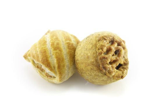 Small tasty pork pie with a small sausage roll on a reflective white background