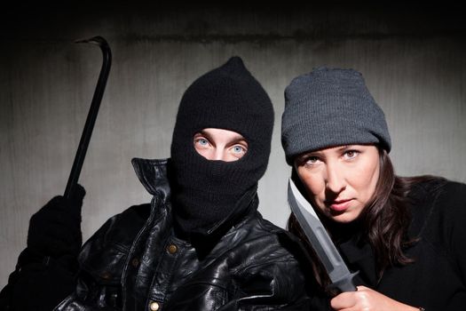 Male and female criminals wielding dangerous weapons