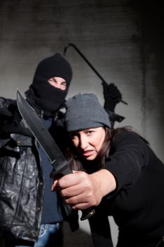 Male and female criminals wielding dangerous weapons