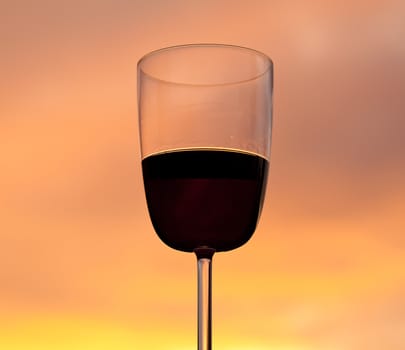 Relaxing with a glass of red wine set against the glowing orange of a brilliant sunset
