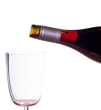 Red or rose wine being poured from screw top wine bottle into an elegant glass and isolated against white
