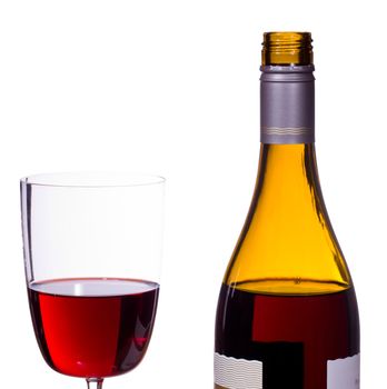 Red or rose wine poured from screw top wine bottle into an elegant glass and isolated against white