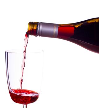 Red or rose wine being poured from screw top wine bottle into an elegant glass and isolated against white