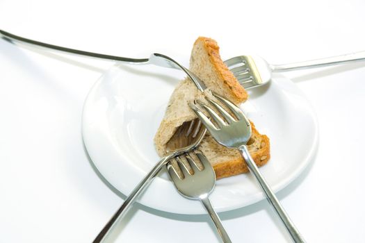 Some forks, white plateau and bread slice on a white background.  The concept of limitation of resources.
The concept  sharing between consumers
