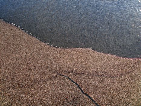 Water gently meeting the sandy shore of Lake Taupo, New Zealand