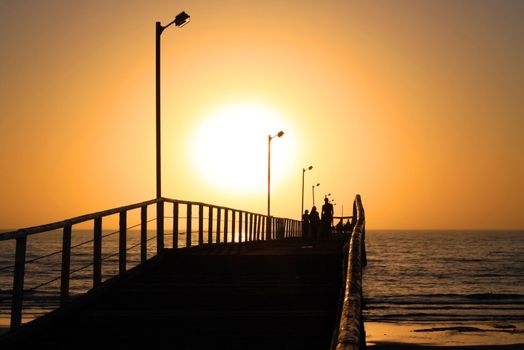 Orange Sunset behind People Walking along Larg's Bay Jetty, Adelaide, Australia
