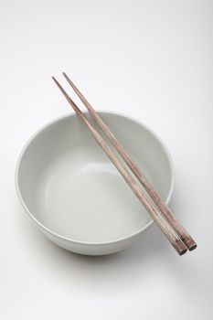 Closeup of chopsticks resting on a bowl