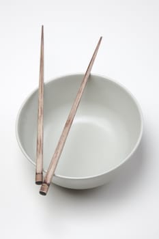 Closeup of chopsticks resting on a bowl