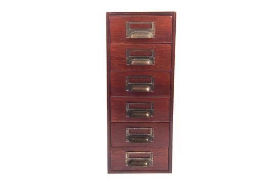 Antique six drawer oak library file card cabinet with brass label holders isolated over white background.