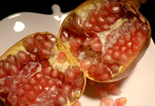 pomegranate fruit on a dish open in half close up