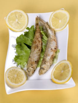 two roast smelt with lemon and lettuce