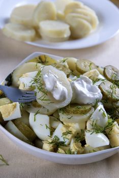 A plate of potato salad layered with hard-boiled eggs 