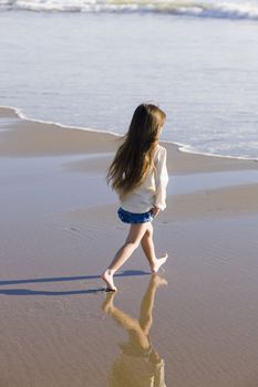 Little Girl Walking in The Water at The Beach