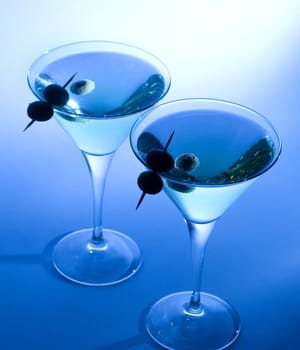 Martini cocktail with olives and blue background
