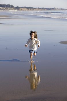 Little Girl Running in The Water at The Beach