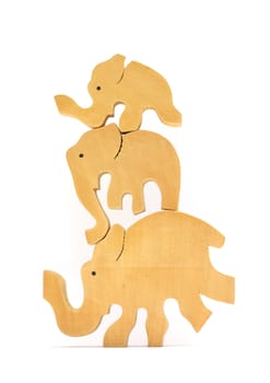 Three traditional nepalese wooden toy elephants balanced on top of each other. Isolated on white.