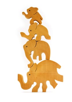 Four traditional nepalese wooden toy elephants balanced on top of each other. Isolated on white.